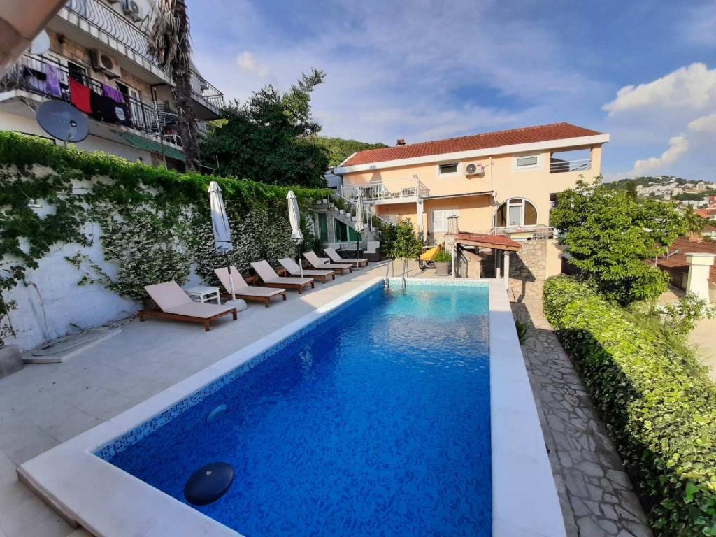 a swimming pool with lounge chairs next to a building at Al Mare in Igalo