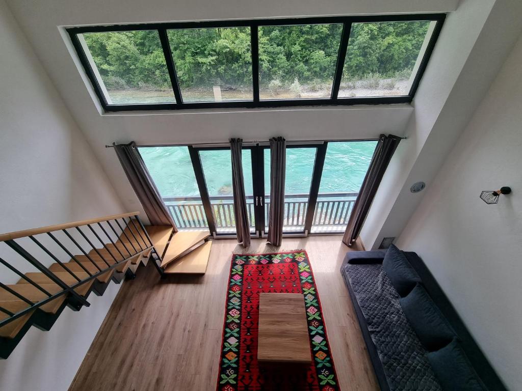een woonkamer met een groot raam en een tapijt bij Apartman Nour in Konjic