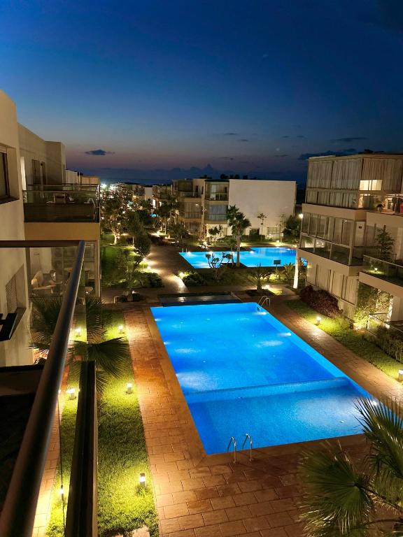 a view of a swimming pool at night at Blue Beach, Sidi Rahal, Appartement pour familles in Sidi Rahal