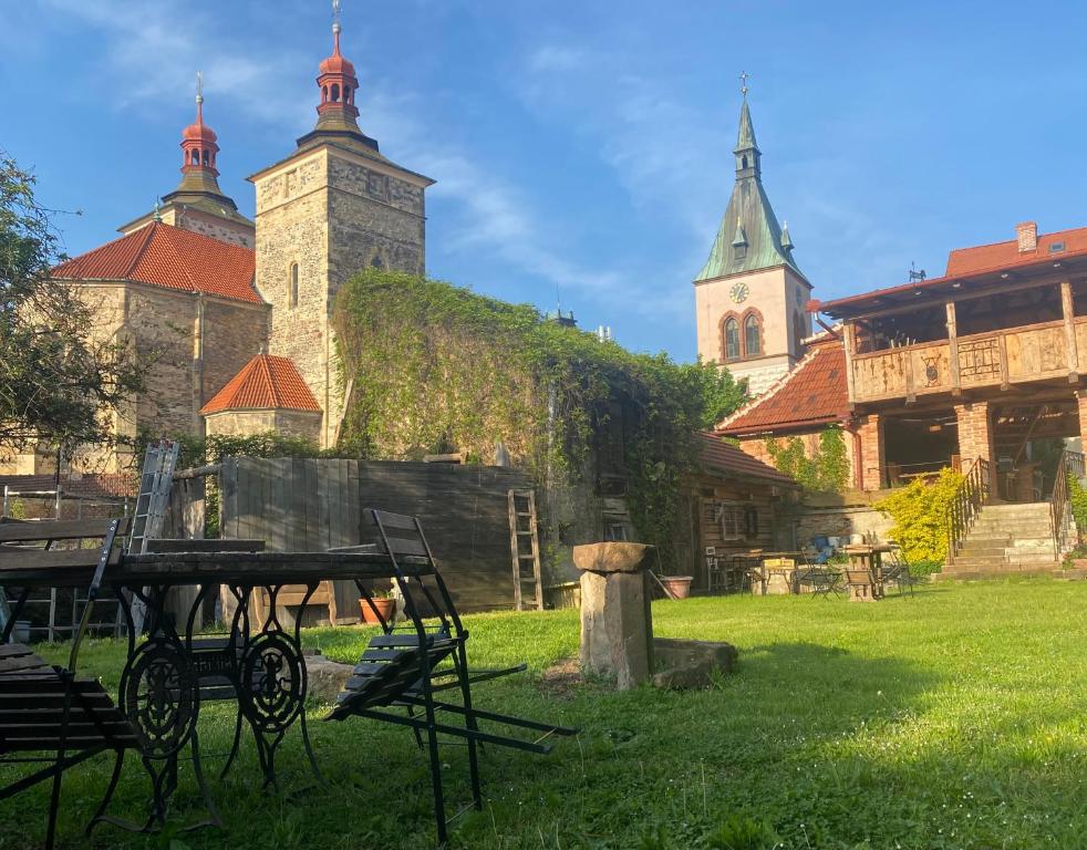 budynek z dwiema wieżami i stołem w trawie w obiekcie Apartmán Bohéma w mieście Kouřim