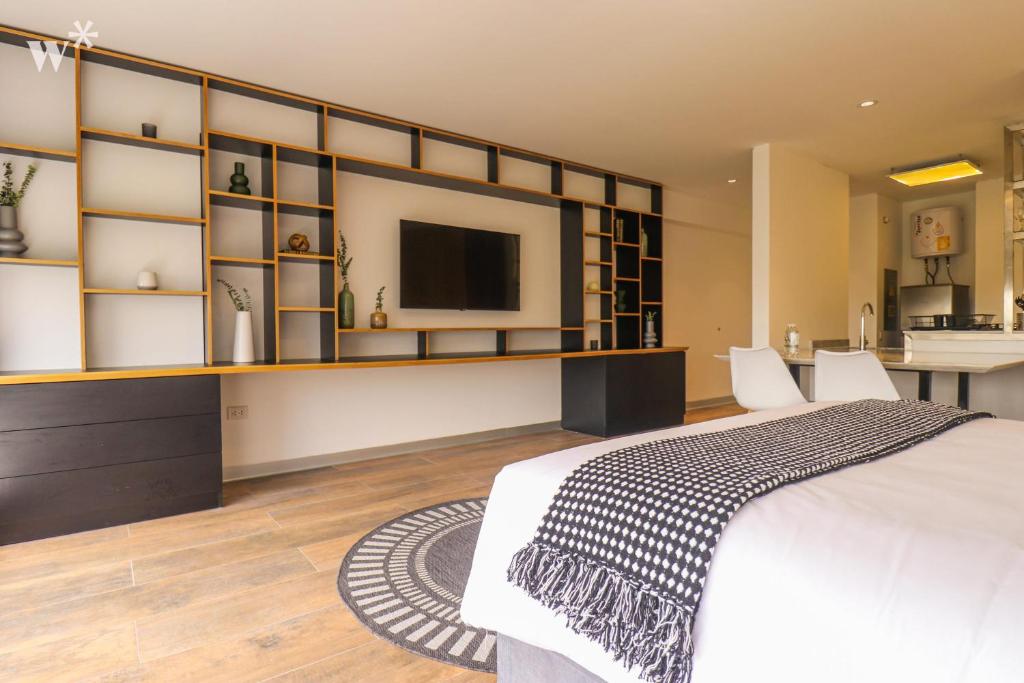 een slaapkamer met een groot bed en een televisie bij Perfect Loft with stunning view in San Isidro in Lima