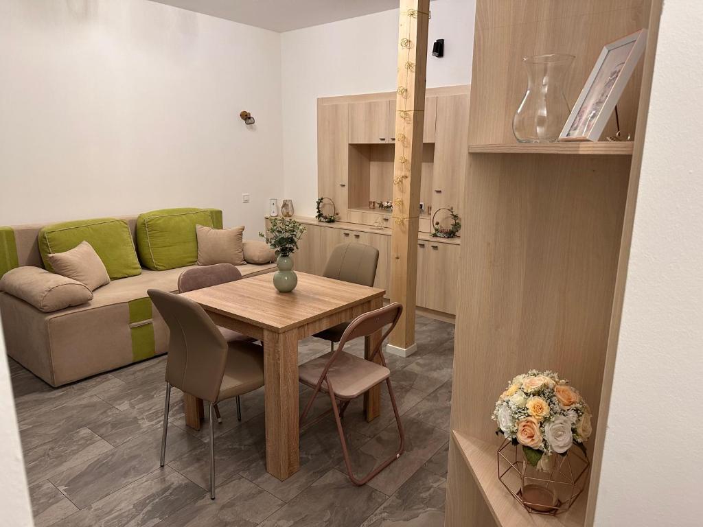 uma sala de estar com uma mesa e um sofá em Infinity Apartman em Esztergom