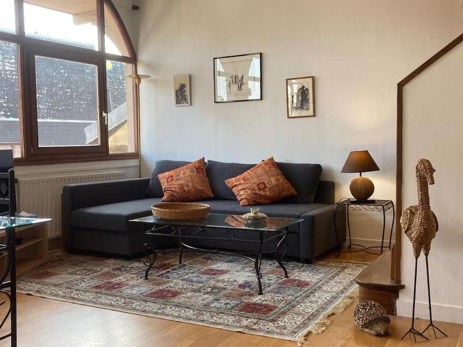 un salon avec un canapé bleu et une table dans l'établissement Appartement duplex de charme, à Rouen