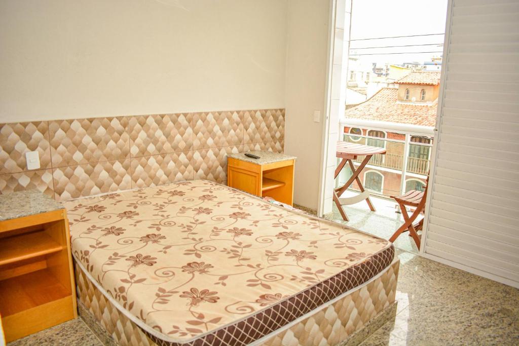 卡波布里奥AP perto da Praia do Forte Cabo Frio的一间带床、书桌和阳台的卧室