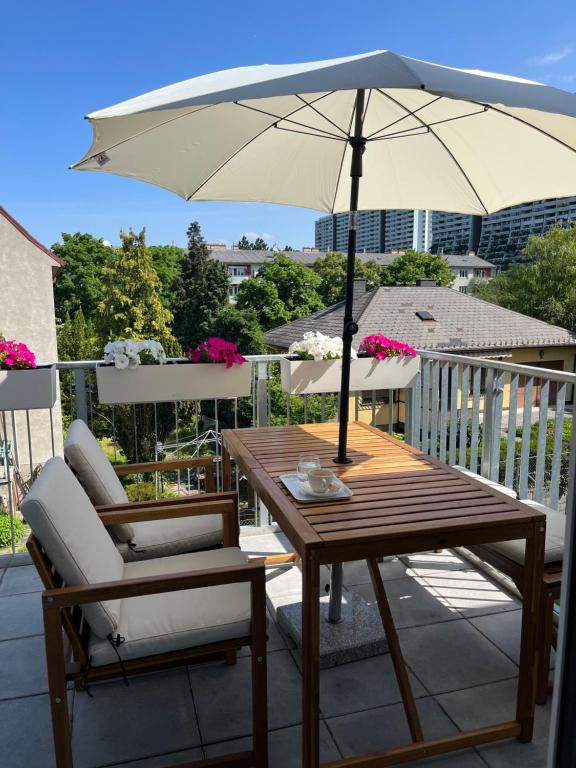 - une table en bois avec un parasol sur le balcon dans l'établissement MiasApp, à Vienne