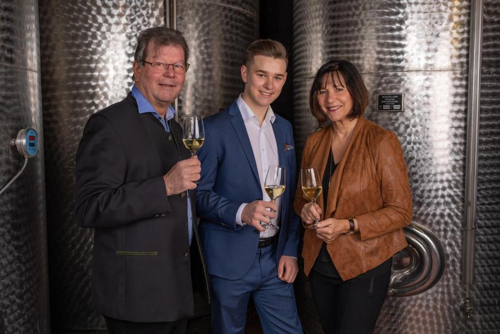 dois homens e uma mulher segurando copos de vinho em Genießerhof Haimer - Hotel Garni em Poysdorf