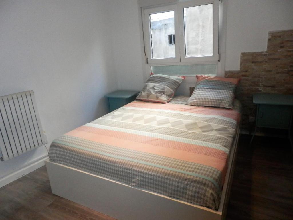 a bed in a small room with a window at Bilbao céntrico 1h Zumaia in Bilbao