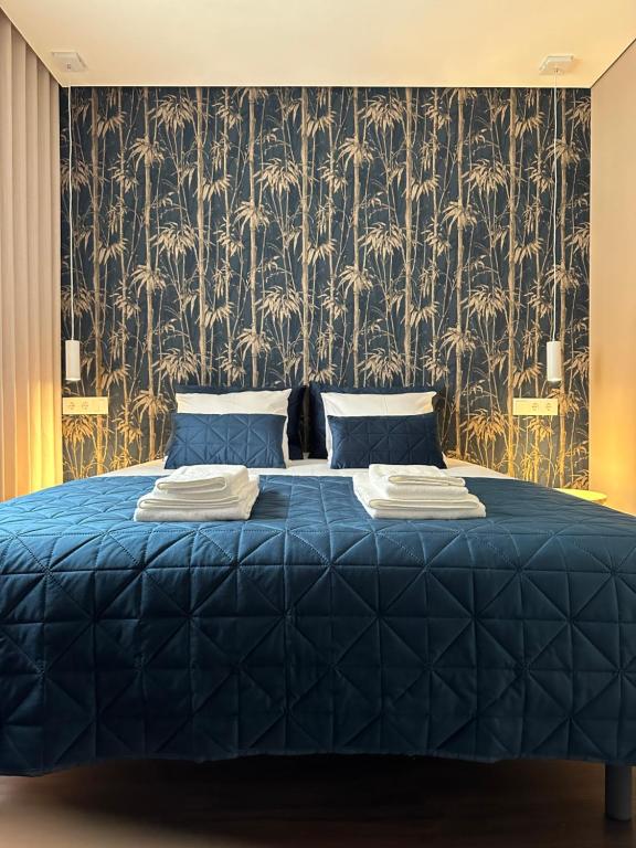 1 dormitorio con cama azul y papel pintado en House Real Companhia, en Vila Nova de Gaia