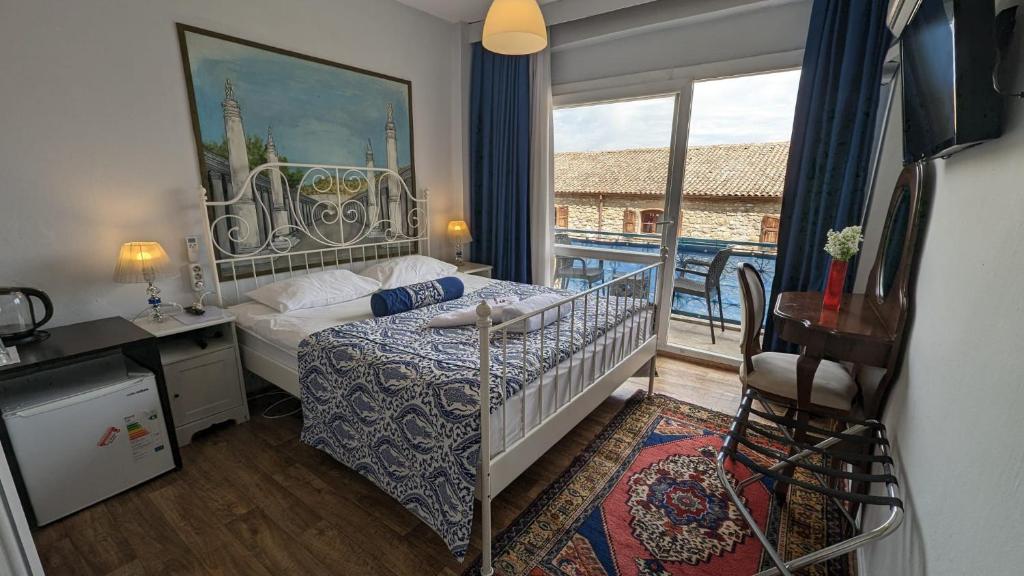 a small bedroom with a bed and a balcony at Urkmez Hotel in Selcuk