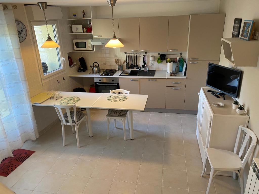 a kitchen with a white table and chairs at Cottage OMAHA - 3 personnes - Plages du débarquement in Formigny