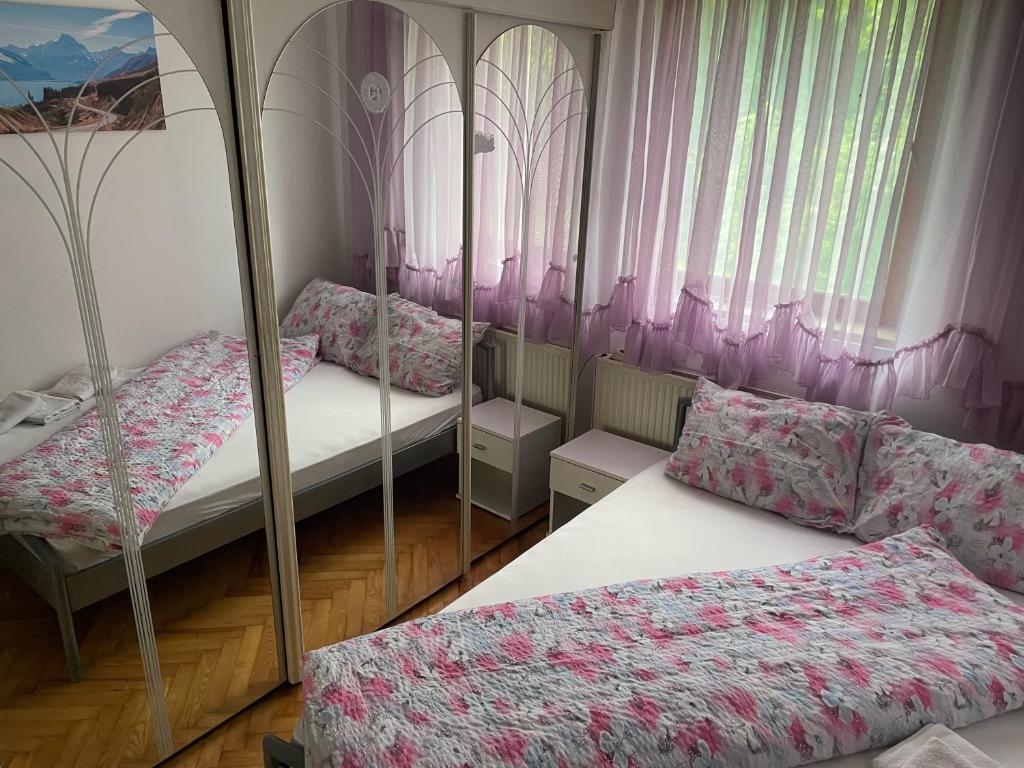 a bedroom with two bunk beds and pink curtains at Slatka sobica za dvoje sa upotrebom zajednicke kuhinje i kupaonice in Zagreb