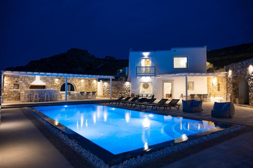 a villa with a swimming pool at night at Villa Orion Mykonos - Magnificent Sea View in Mikonos