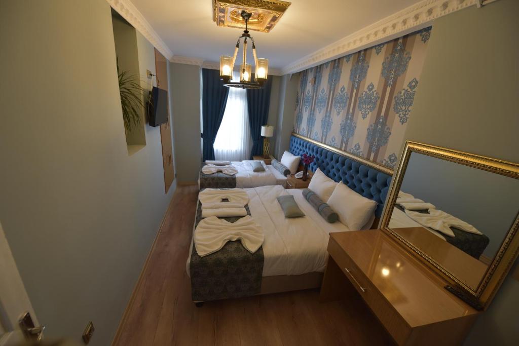 イスタンブールにあるİSTA Golden Palace Hotelのベッド2台と鏡が備わるホテルルームです。