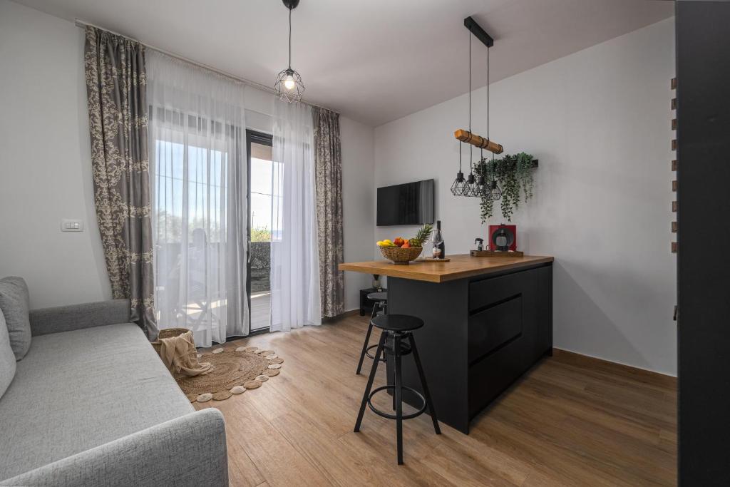 ein Wohnzimmer mit einem Sofa und einem Schreibtisch in einem Zimmer in der Unterkunft Apartment KriLa in Kaštela
