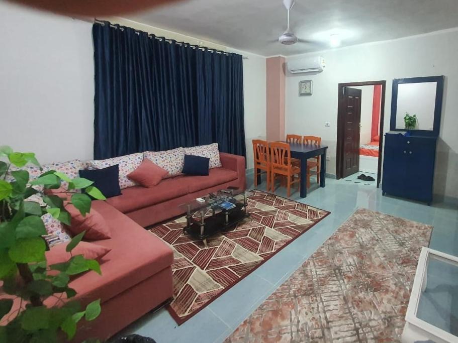 a living room with a red couch and a table at Abeer Suites 3 basement in Hurghada