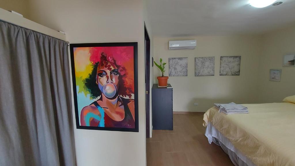 a bedroom with a painting of a man on the wall at Casa Kamanda, Zona Colonial, Santo Domingo in Santo Domingo