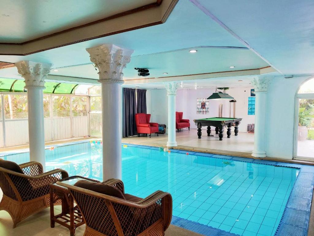 a swimming pool with chairs and a pool table at The Park Pool Villa Pattaya in Pattaya Central