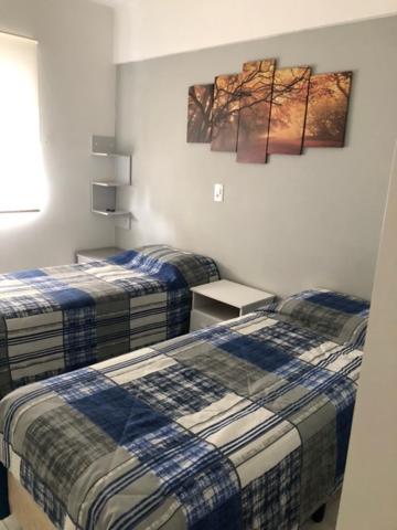 a bedroom with two beds and a painting on the wall at Rua Dr Diogo de Faria, 671 apto 81 in Sao Paulo