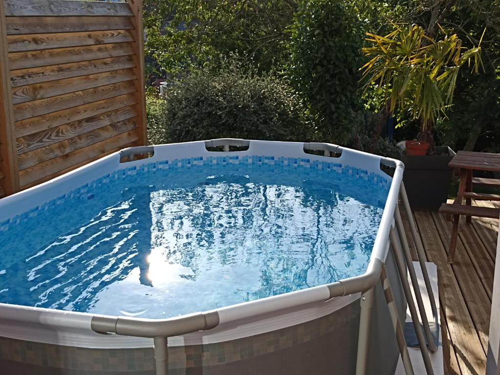 a hot tub in a backyard with blue water at Belle Vue in Le Mans