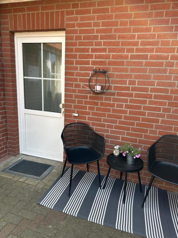 two chairs and a table in front of a door at Renovierte Ferienwohnung in Nienburg Erichshagen in Erichshagen