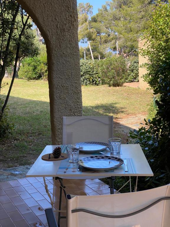 una mesa blanca con dos platos y vasos. en Cassetta 92 Marie-Pierre, en Lumio