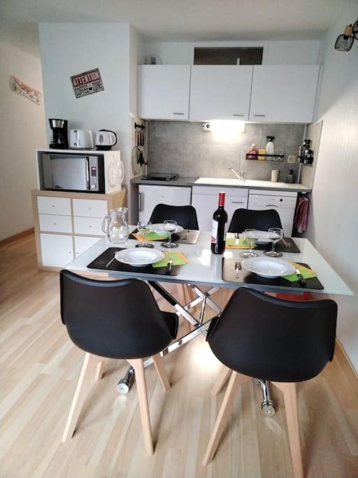 - une cuisine avec une table et quatre chaises dans l'établissement Appartement dans une Résidence Calme (4 Personnes), à Saint-Lary-Soulan