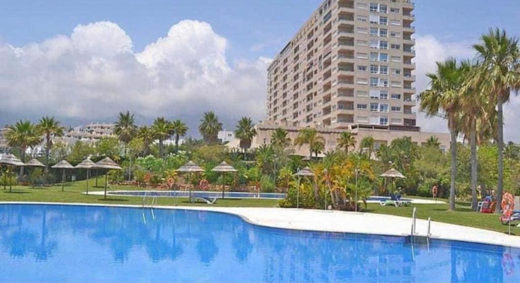una grande piscina di fronte a un grande edificio di Apartamento Playa Torrequebrada Coloso a Benalmádena