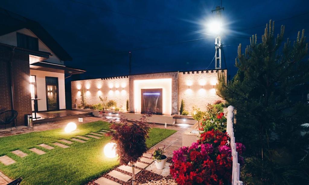 une maison avec un jardin éclairé la nuit dans l'établissement Casa Budisteanu, à Focşani