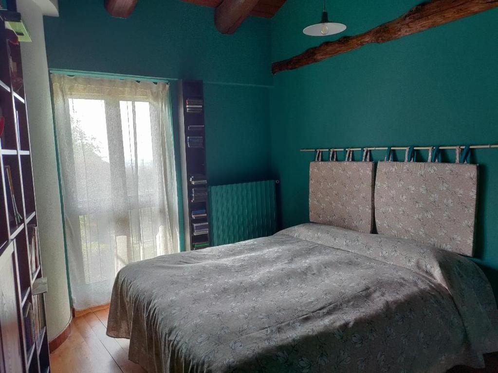 a bedroom with a bed with a green wall at Il giardino di Alcesti in Pino Torinese
