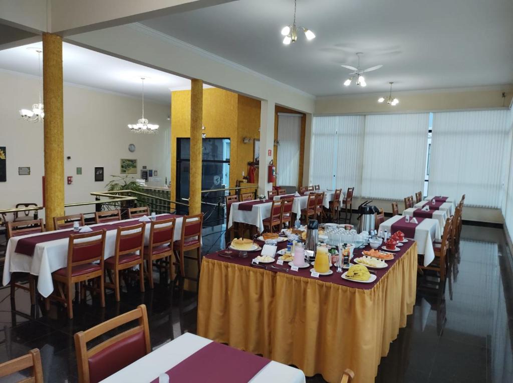 a banquet hall with tables and chairs with food on them at HOTEL SOARES CAMARGO in Salesópolis