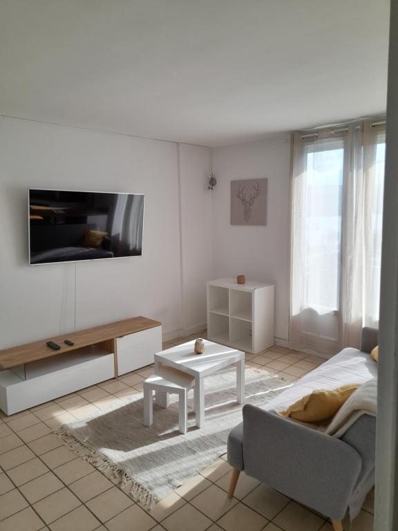 a white living room with a couch and a table at superbe duplex avec parking gratuit in Grenoble