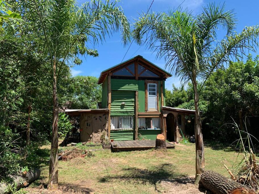 una pequeña casa verde en medio de un campo en Cabaña La Sencillita, en Neptunia