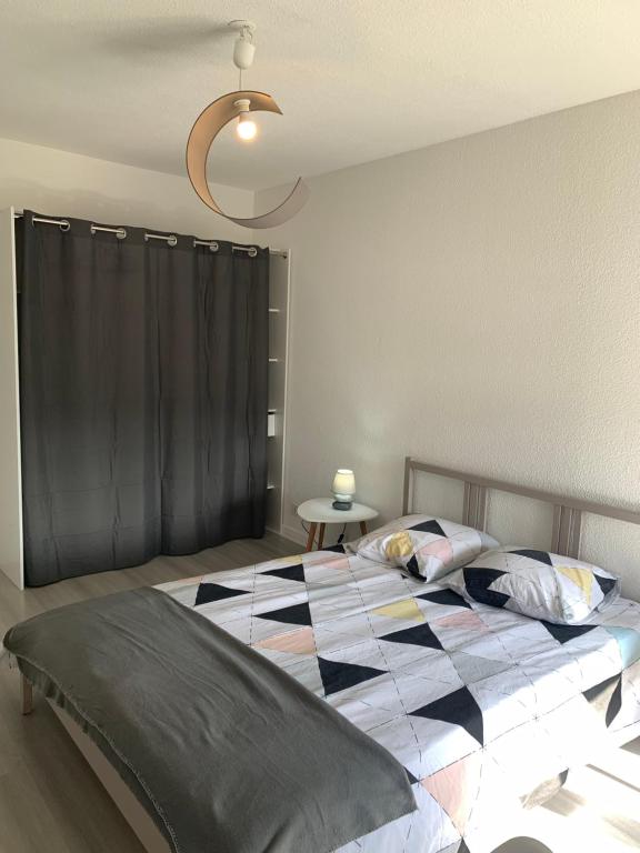 - une chambre avec un lit et une couverture en damier dans l'établissement Appartement Chaleureux avec 2 grandes chambres, à Saint-Rambert-dʼAlbon