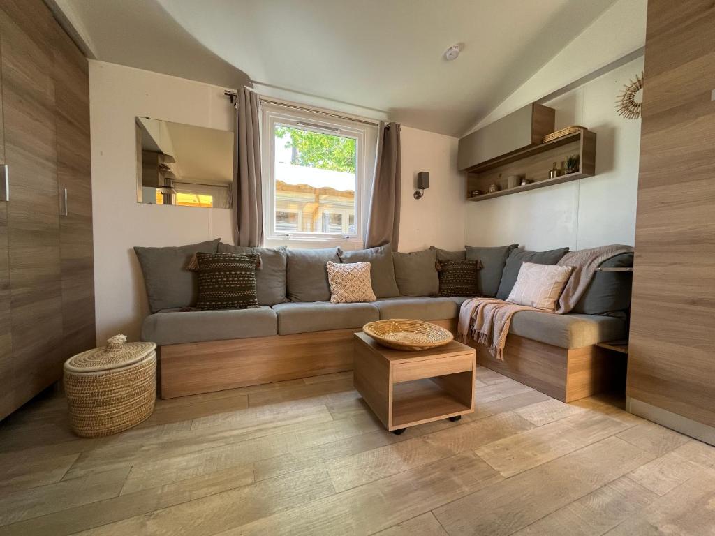 uma sala de estar com um sofá e uma janela em Mobil home climatisé em Lège-Cap-Ferret