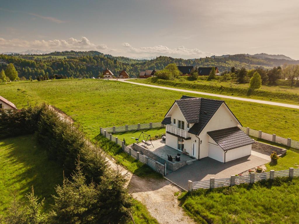 an aerial view of a white house in a field at Domek nad Zalewem in Kluszkowce