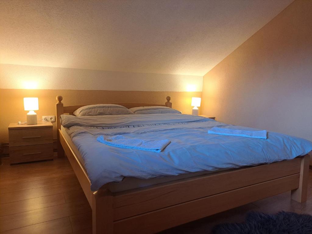 um quarto com uma cama grande com lençóis e almofadas azuis em Apartman Avram em Kotor-Varoš