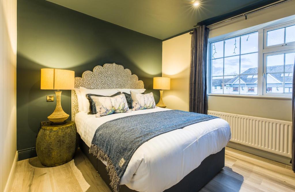um quarto com uma cama grande e uma janela em The Lodges at Castle Lodge em Killarney