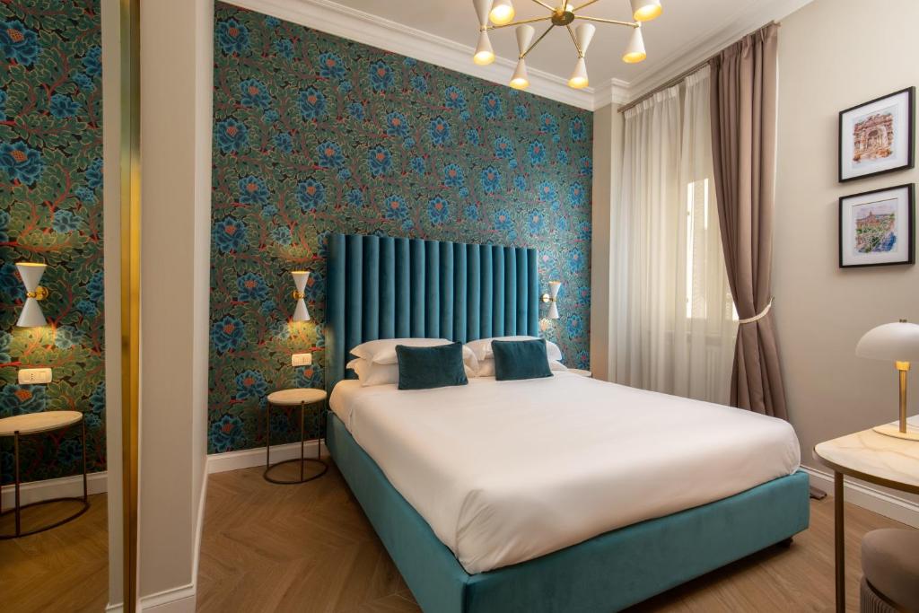 1 dormitorio con 1 cama grande y cabecero azul en Porta Castello Suites, en Roma