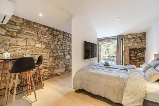 a bedroom with a bed and a stone wall at Villa Harmony in Supetar