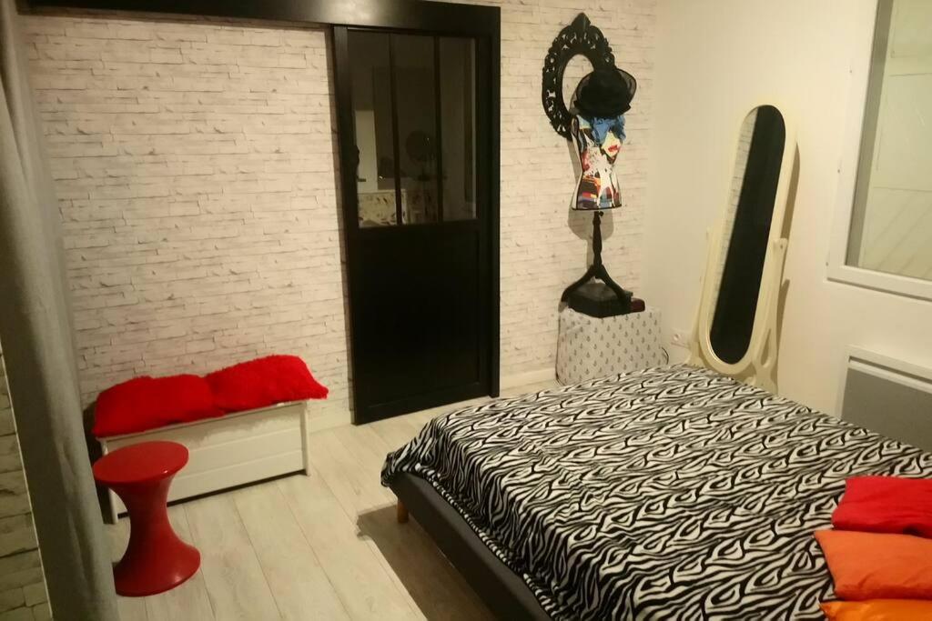 una camera da letto con un letto e un muro di mattoni di Petite maison mitoyenne, proche port & Arcachon a La Teste-de-Buch