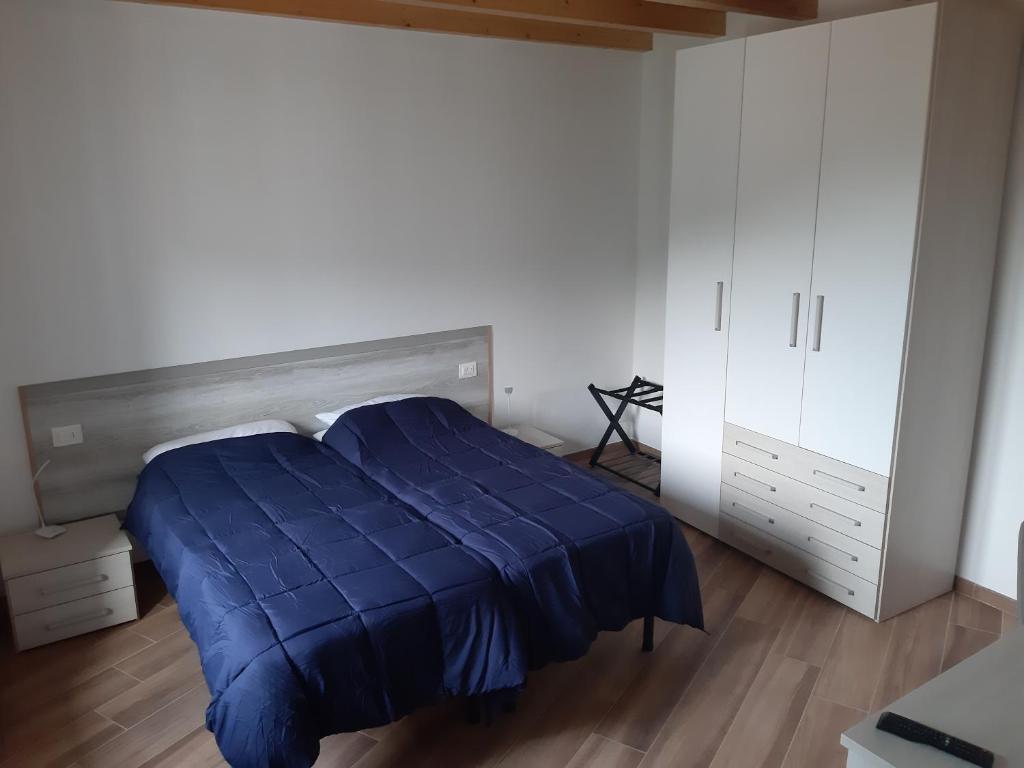 1 dormitorio con edredón azul en la cama en Il Glicine B&b, en Voltaggio