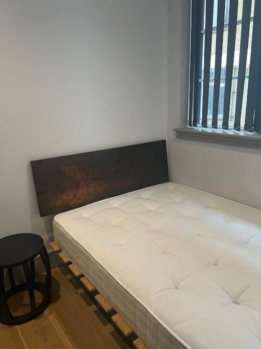 a bed sitting in a room next to a window at 1 bed Apartment in Whitechapel in London