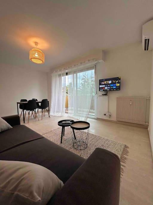 un salon avec un canapé et une salle à manger dans l'établissement Studio rénové à deux pas de la mer, à Vallauris