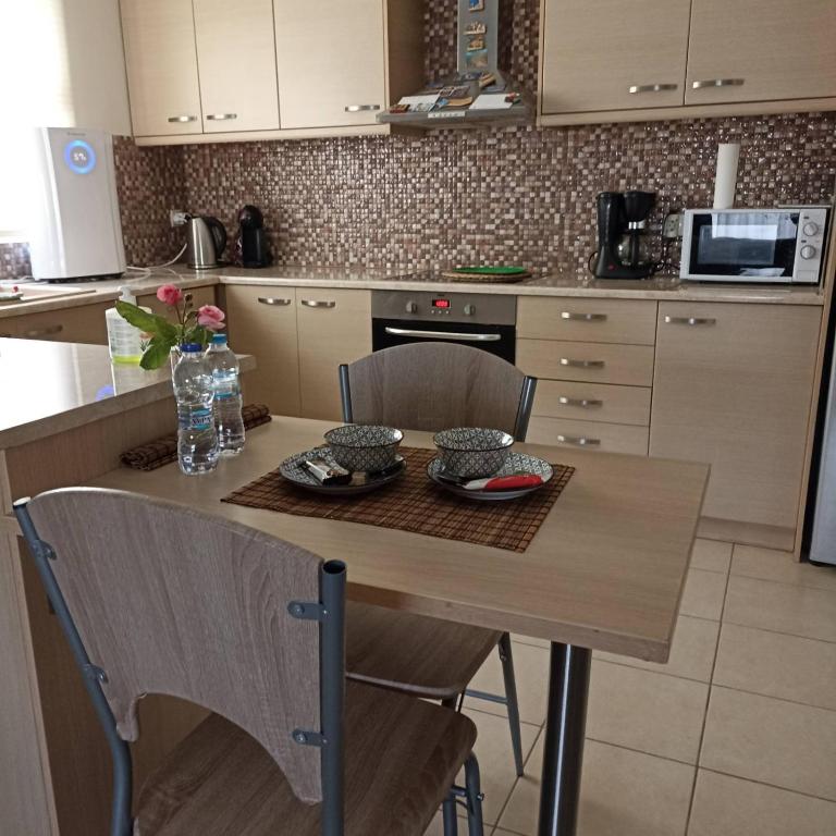 a kitchen with a table with two chairs and a table at Nàra house in Áyios Spirídhon