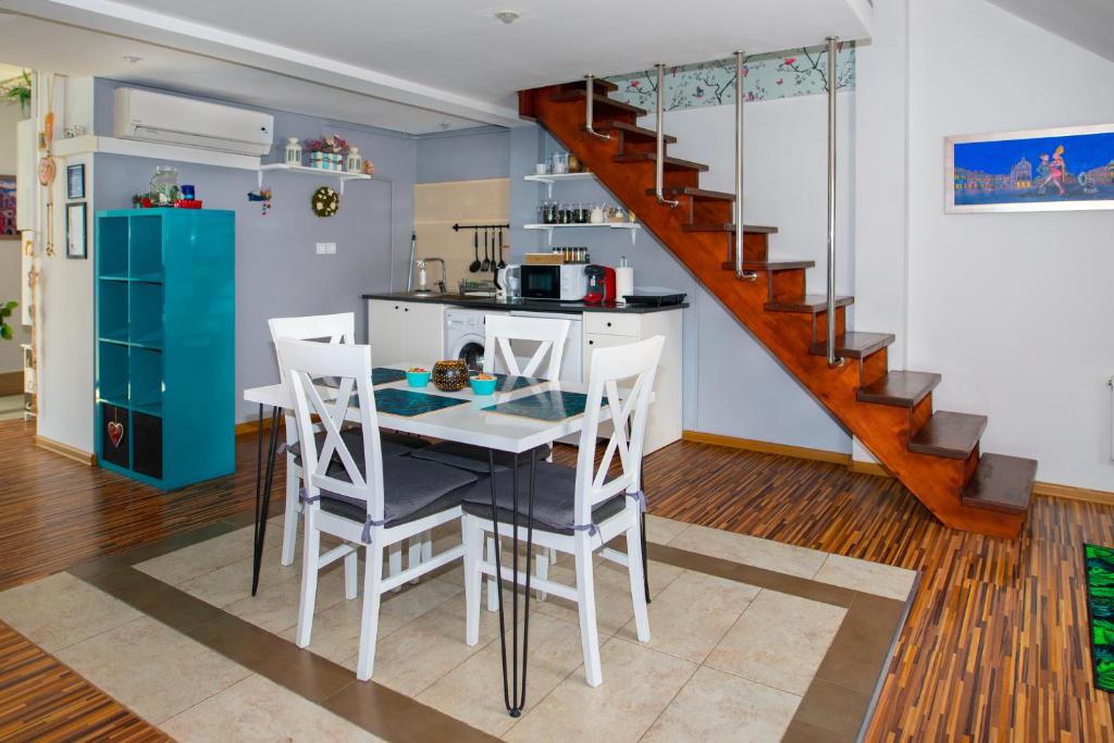 a kitchen with a table and chairs and a staircase at Trend Apartment Old Market Rzeszów in Rzeszów
