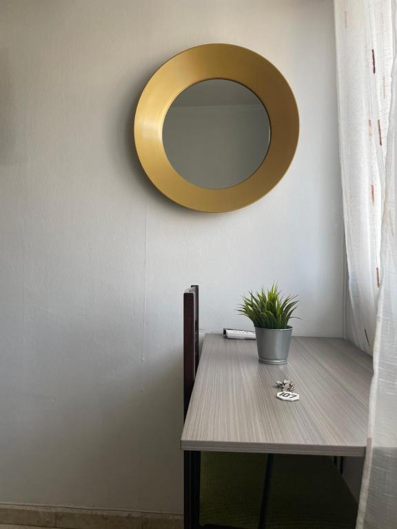 a dining room table with a gold mirror on the wall at Hostal Mediterraneo in Torre del Mar
