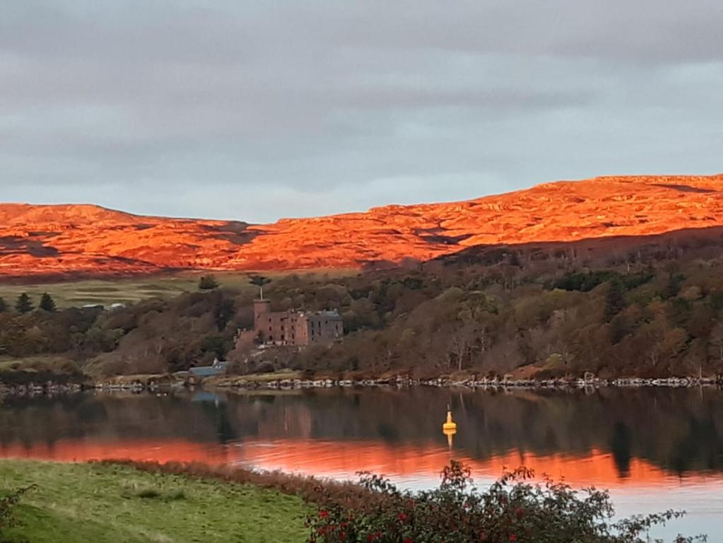 a view of a lake with a castle in the distance at Castle View Apartment in Dunvegan