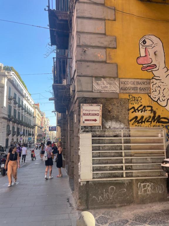 a group of people walking down a street next to a building at Ginevra house in Naples