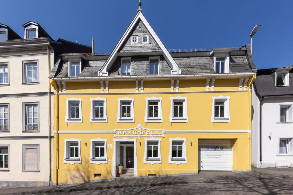 a yellow building in front of a white building at FerienNest Haus Braunfels in Bad Ems