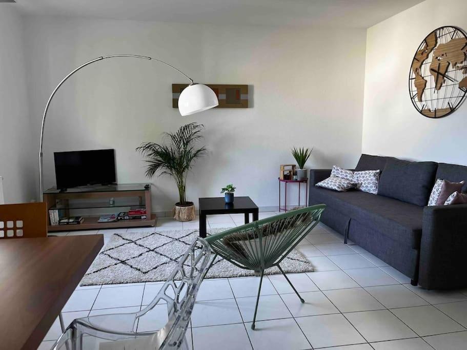 uma sala de estar com um sofá e uma mesa em L'Etoile em Lutterbach